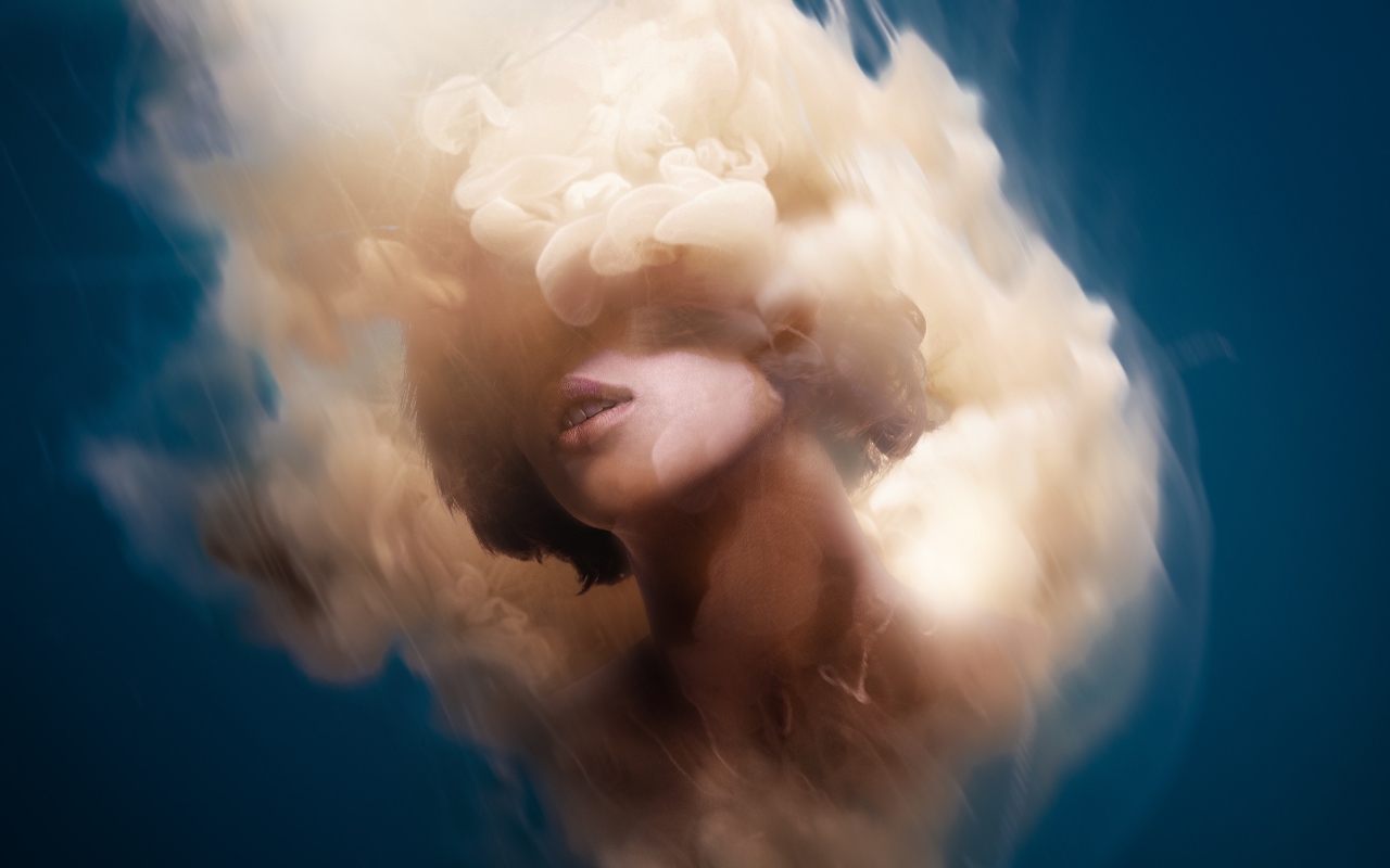 Лицо девушки в дыму на голубом фоне, иллюзия