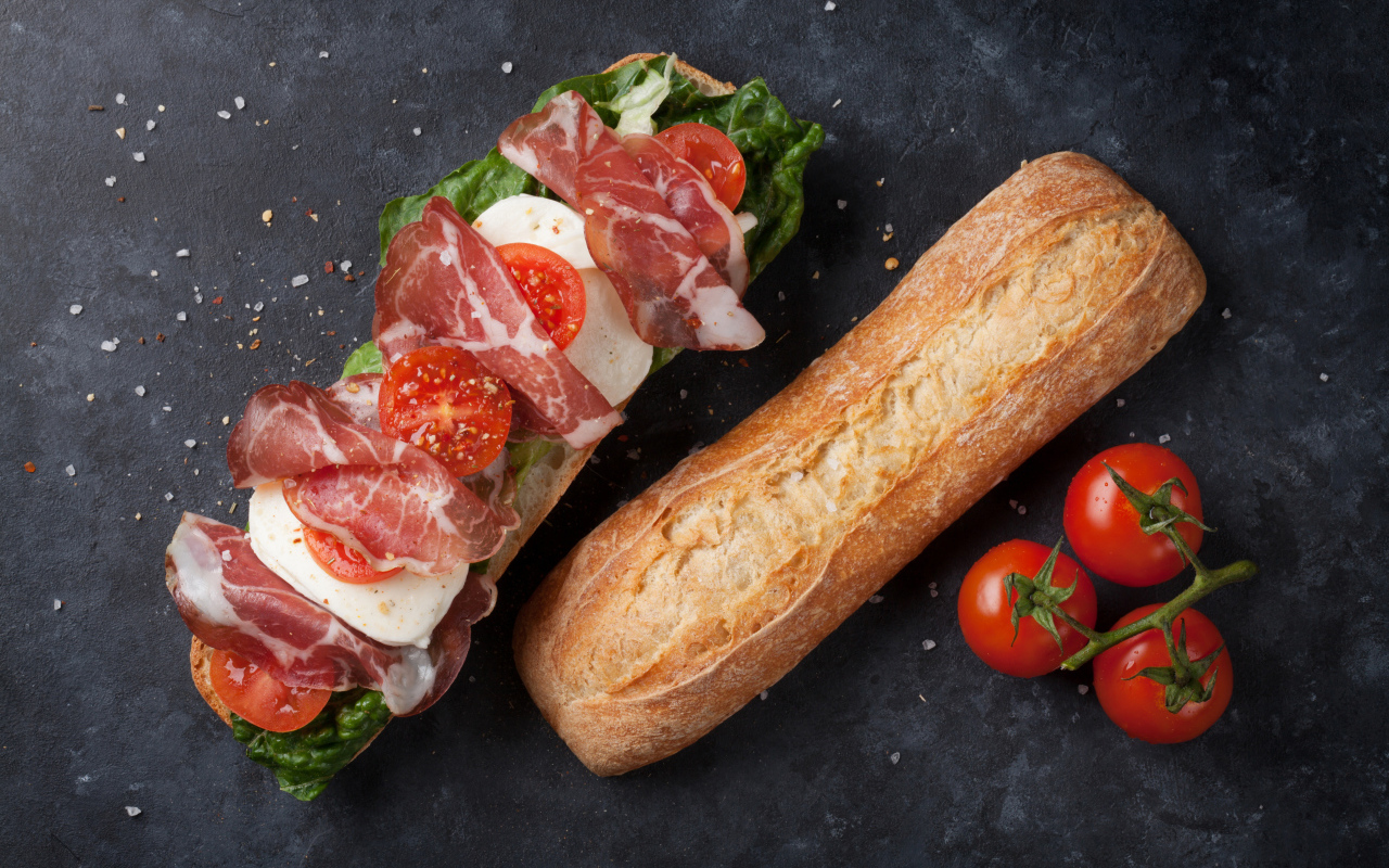 Бутерброд с ветчиной, помидорами, яйцом и листьями салата