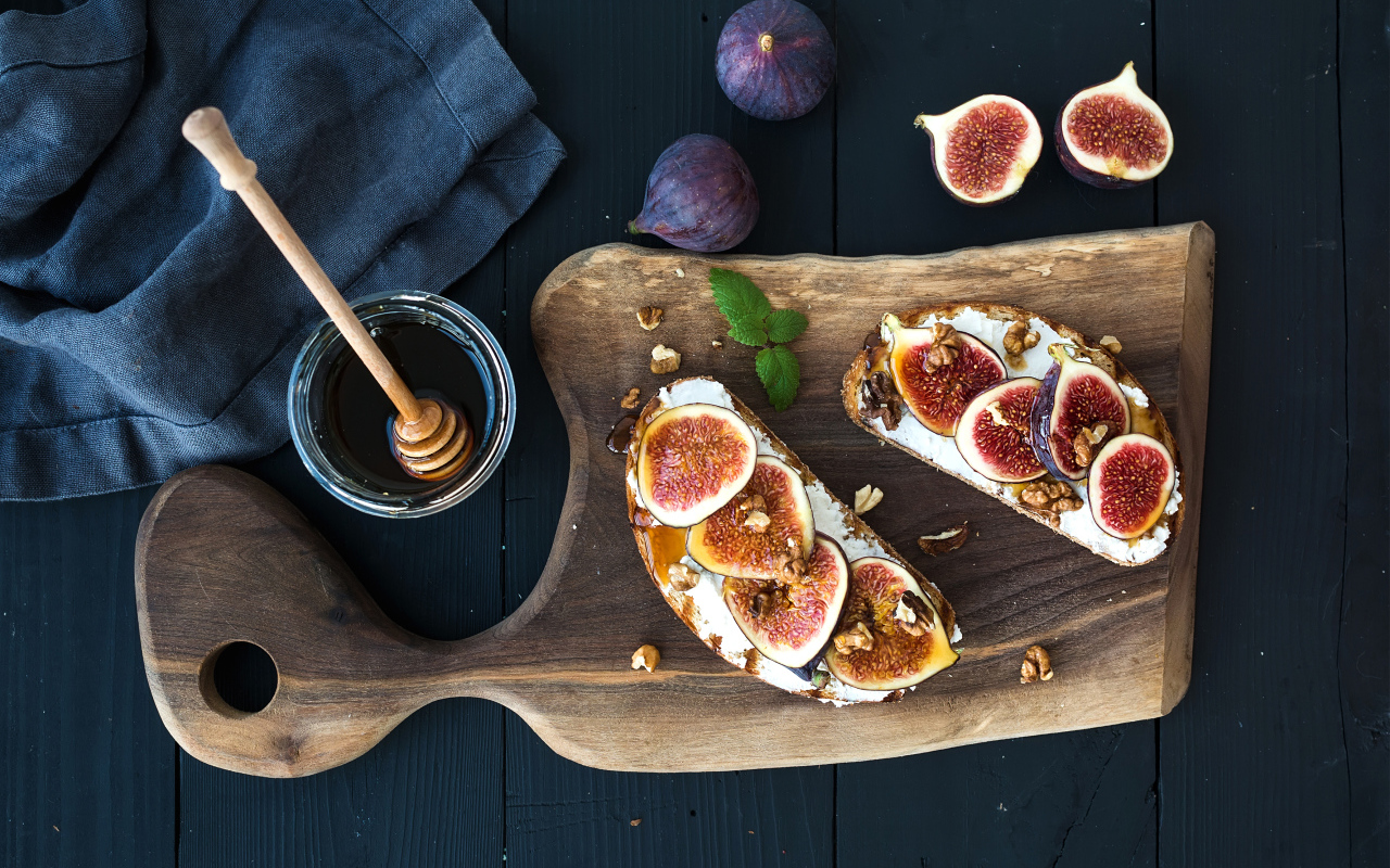 Бутерброды с инжиром на разделочной доске с медом 