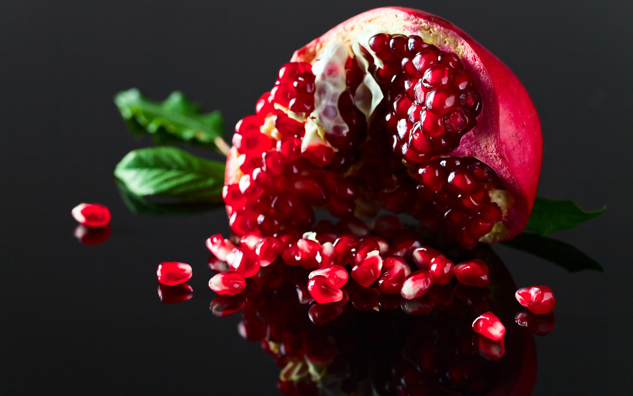 Чищенный гранат на сером фоне крупным планом