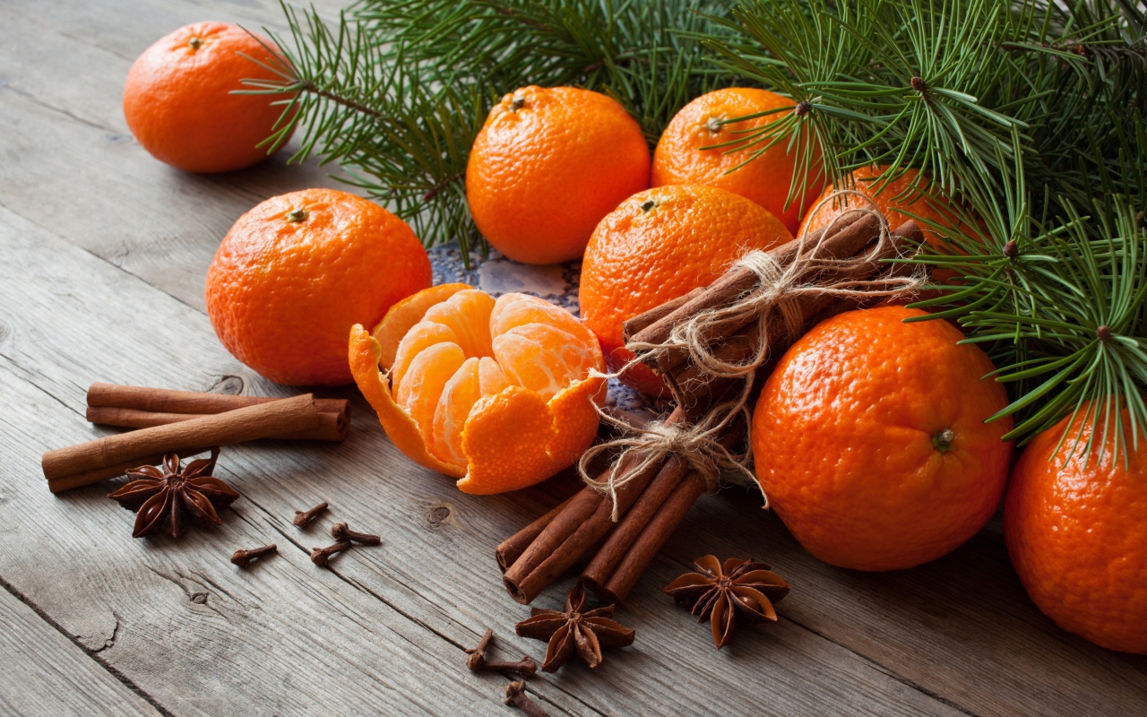 Вкусные спелые мандарины с корицей и бадьяном на столе с еловой веткой