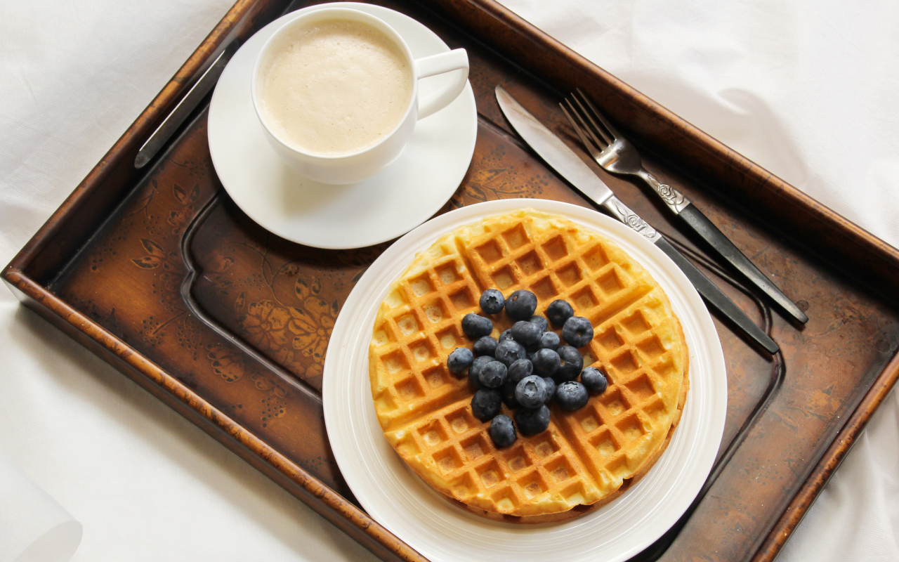 Чашка кофе и сладкие вафли с черникой на завтрак