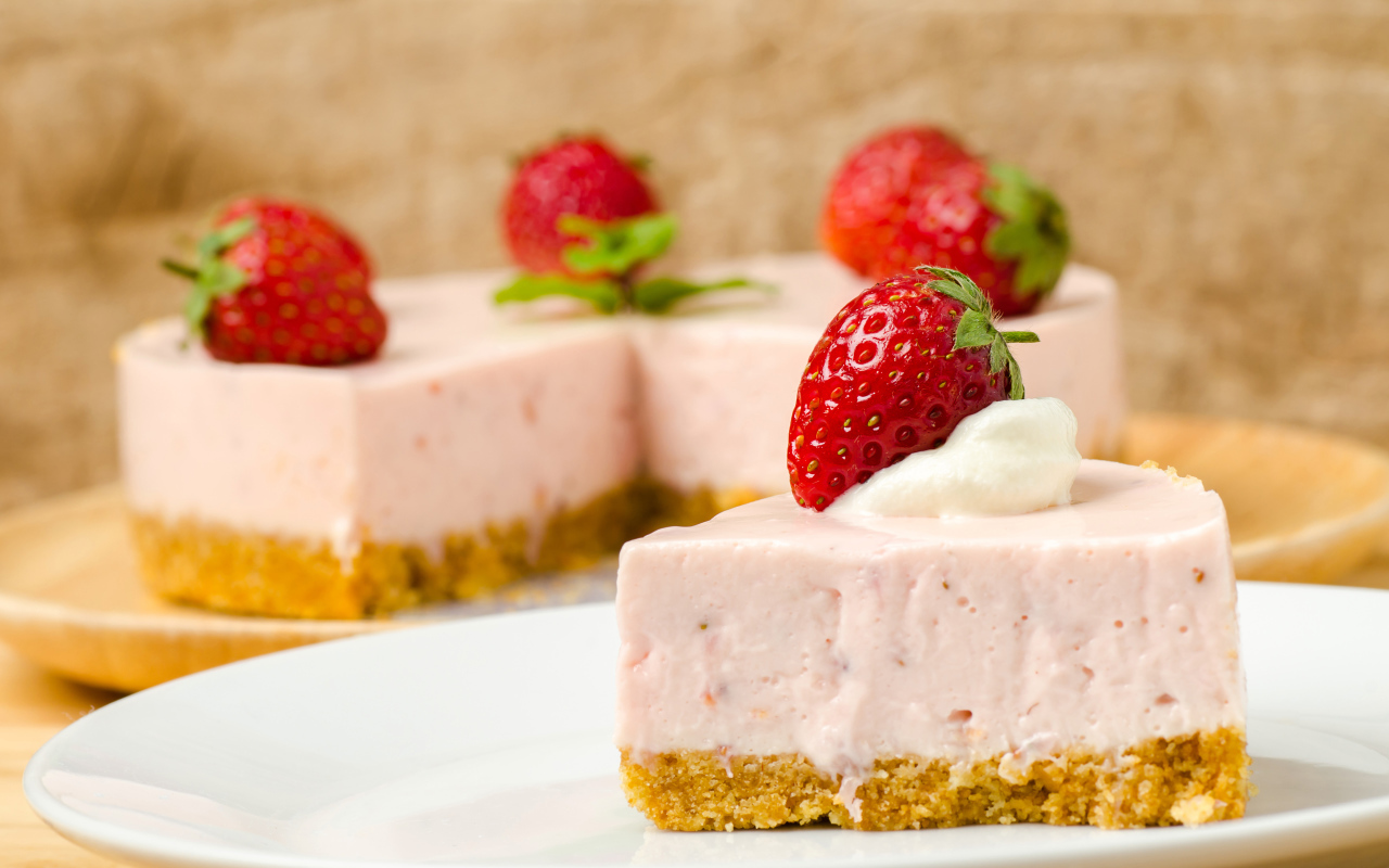 Кусок торта с клубникой на белой тарелке