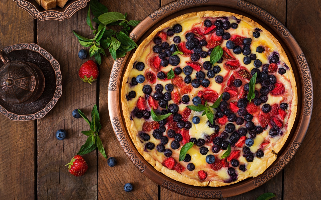 Аппетитный пирог с ягодами на деревянном столе