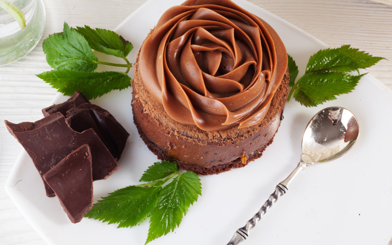 Пирожное с шоколадной кремовой розой на тарелке