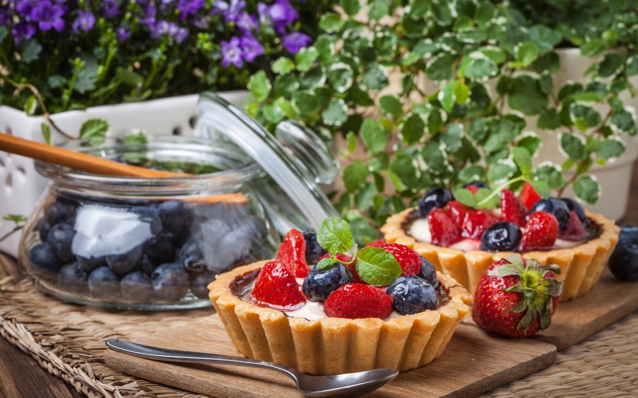 Пирожные с ягодами клубники и черники на столе