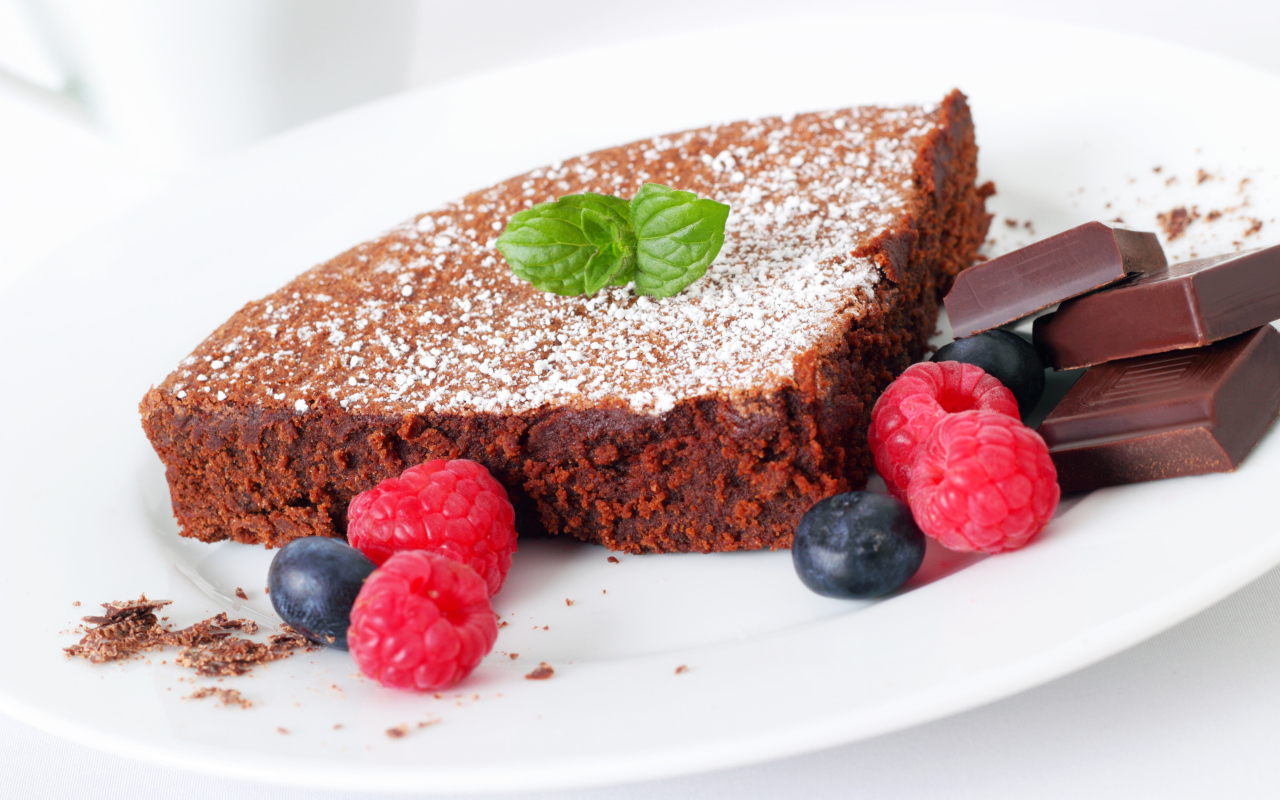 Шоколадный десерт брауни с ягодами малины и черники