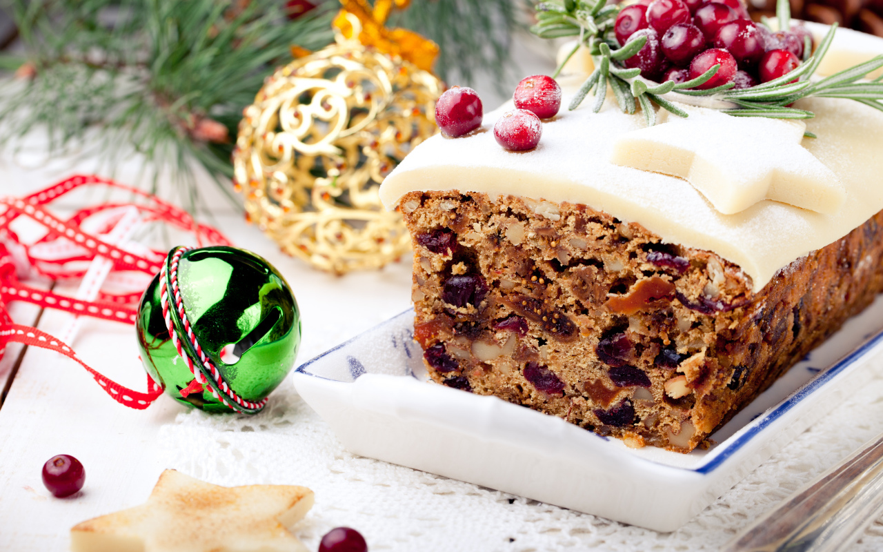 Праздничный новогодний кекс с сухофруктами и игрушками на столе