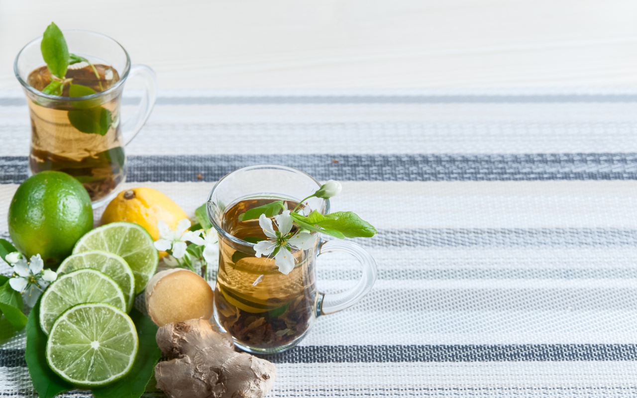 Стеклянные чашки с чаем на столе с имбирем и лаймом