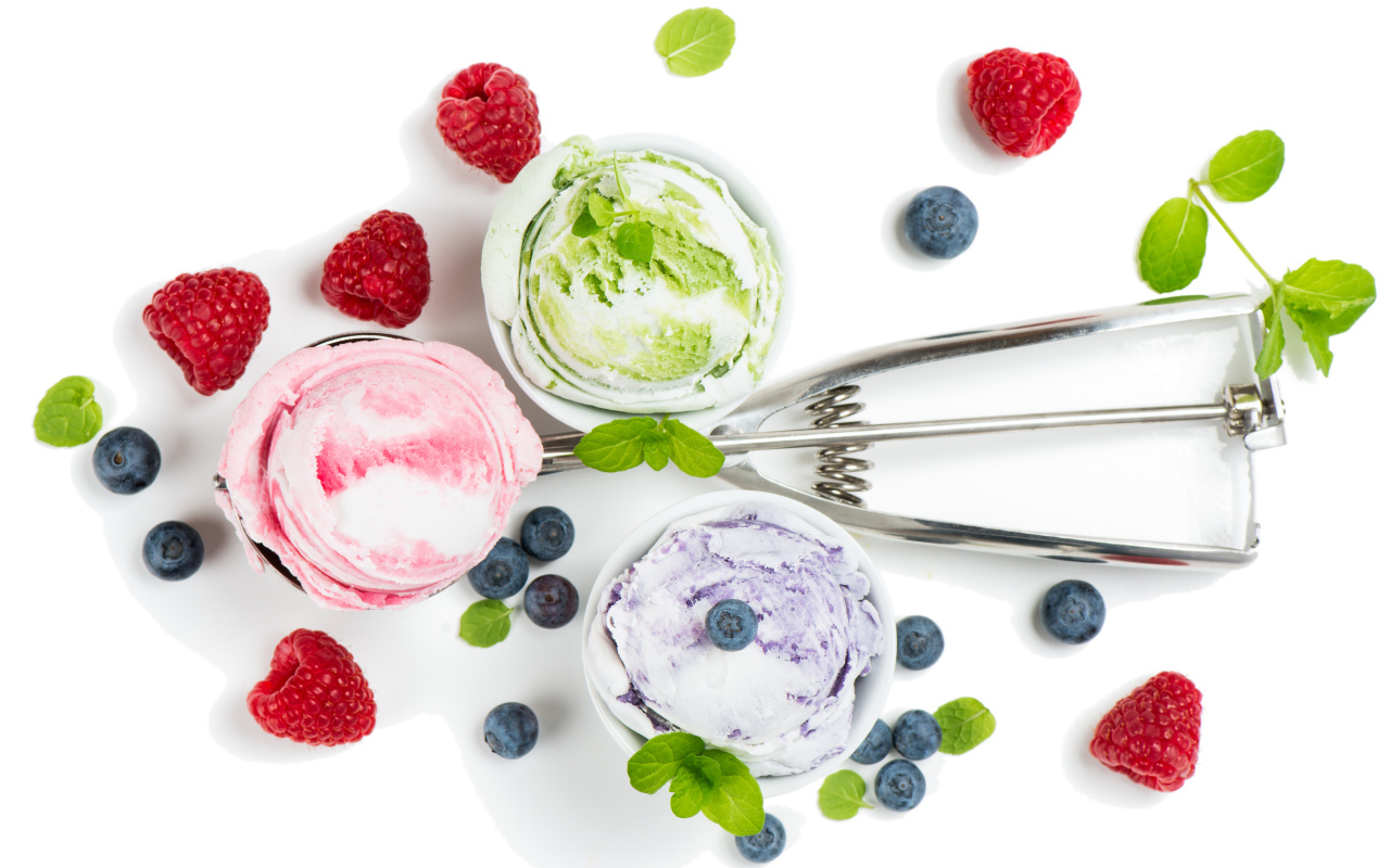 Шарики мороженого на столе с ягодами черники и малины 