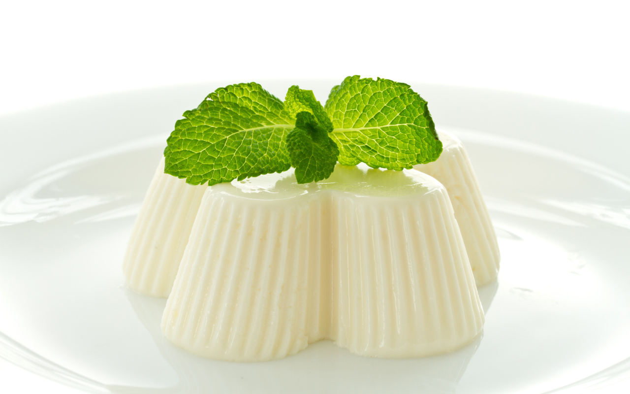 Молочное желе с мятой на белой тарелке 