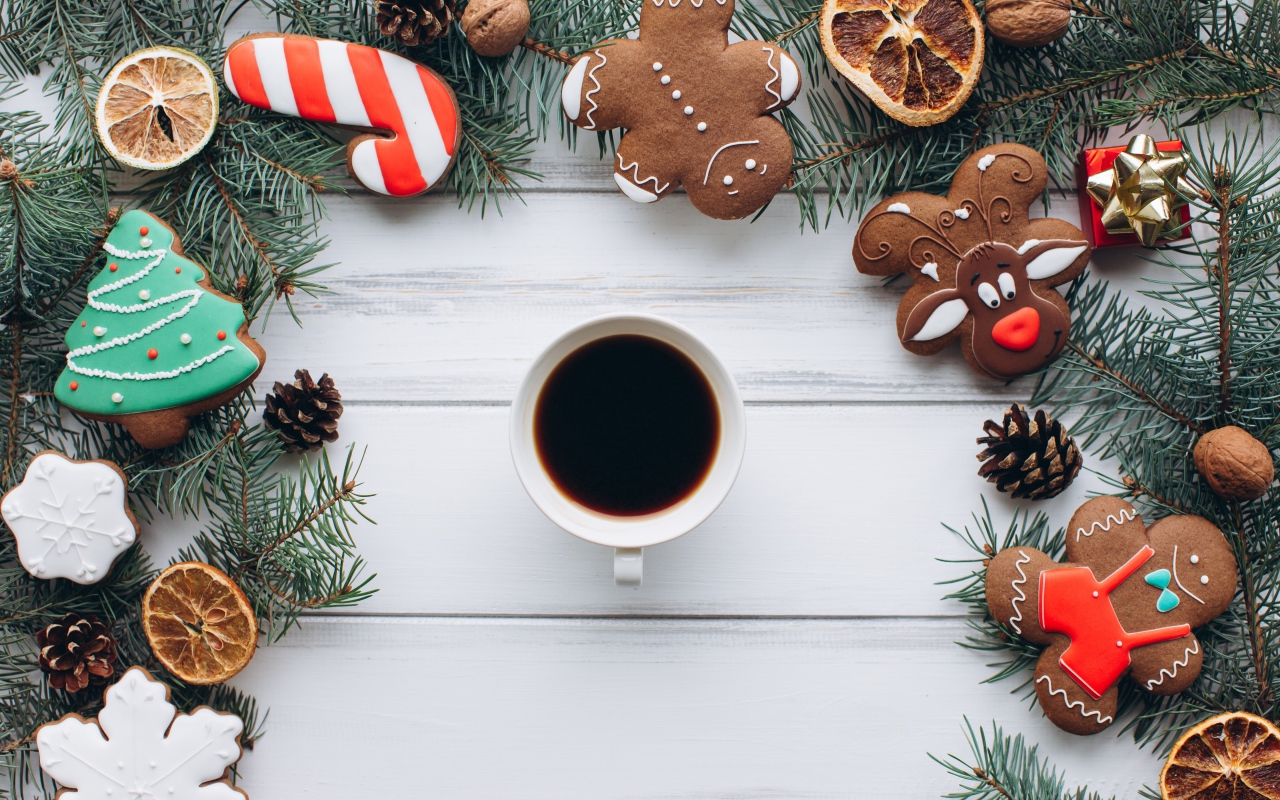 Чашка кофе на деревянном столе с имбирным печенье, еловыми ветками и декором