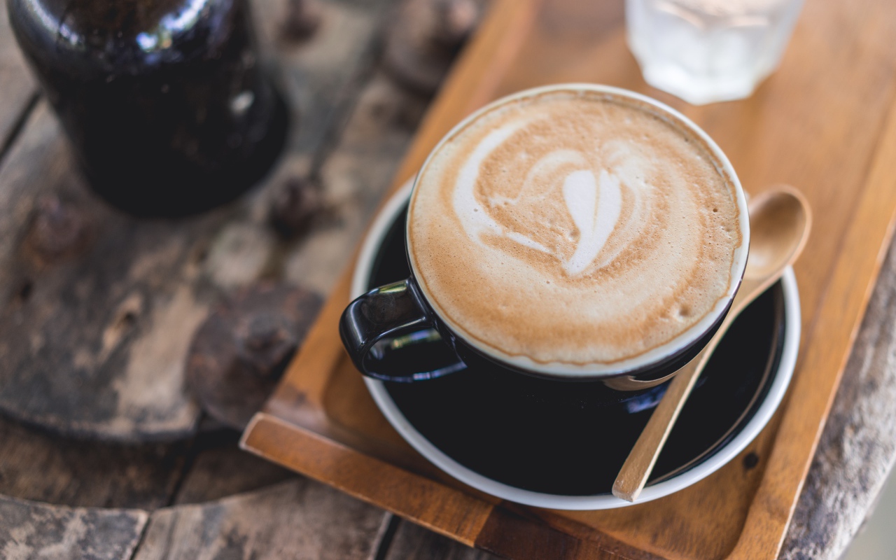 Большая чашка кофе с пеной на столе