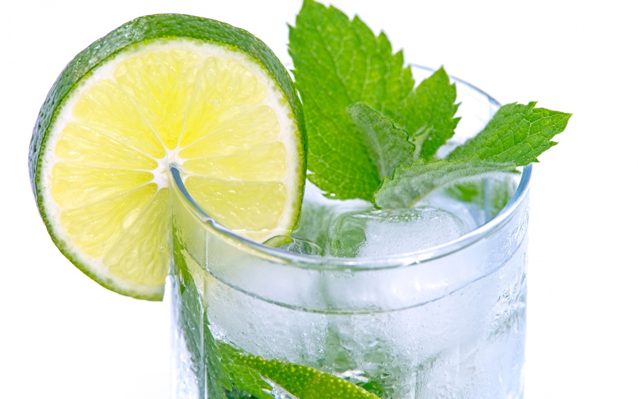 Стакан с освежающим напитком с мятой и лаймом на белом фоне