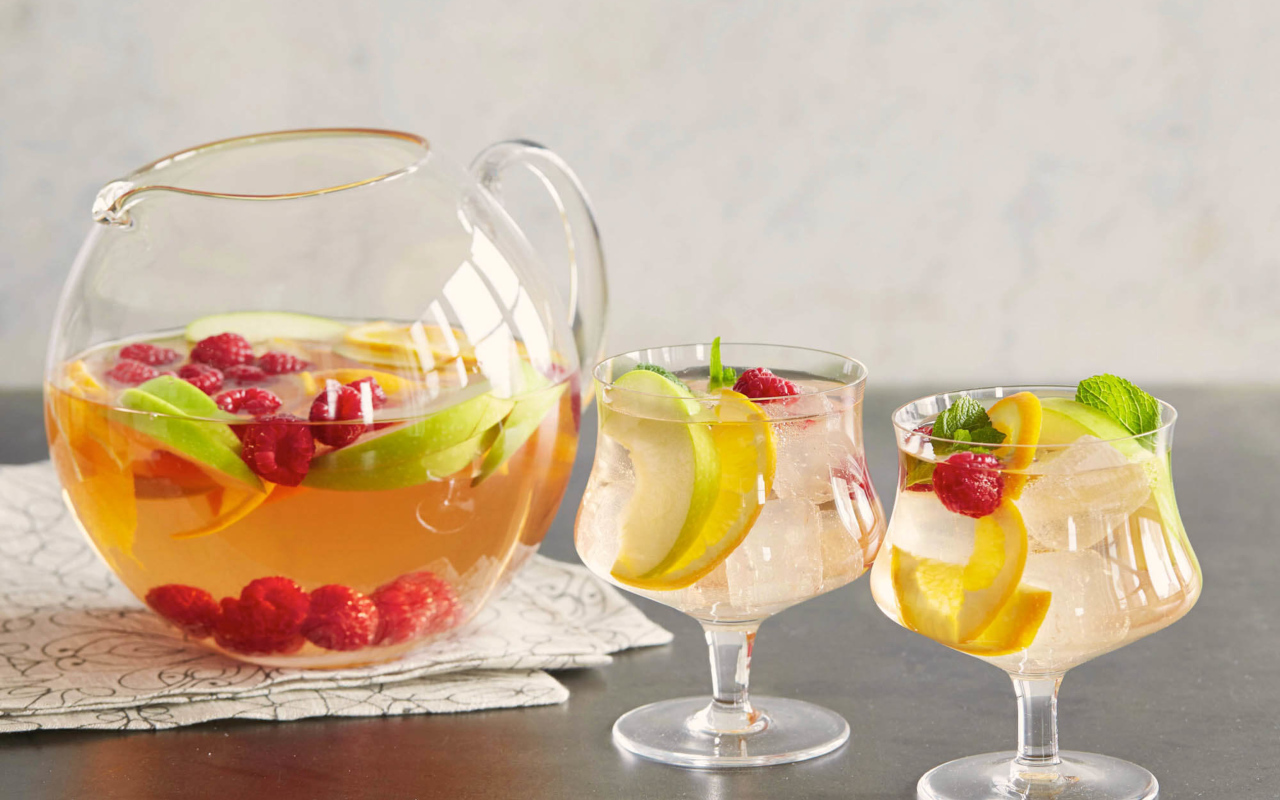 Лимонад в графине на столе с бокалами 