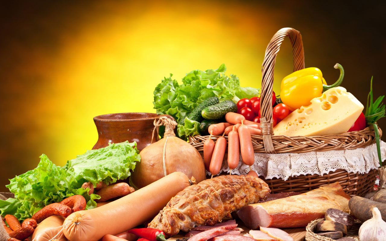 Аппетитные мясные продукты на столе с корзиной овощей