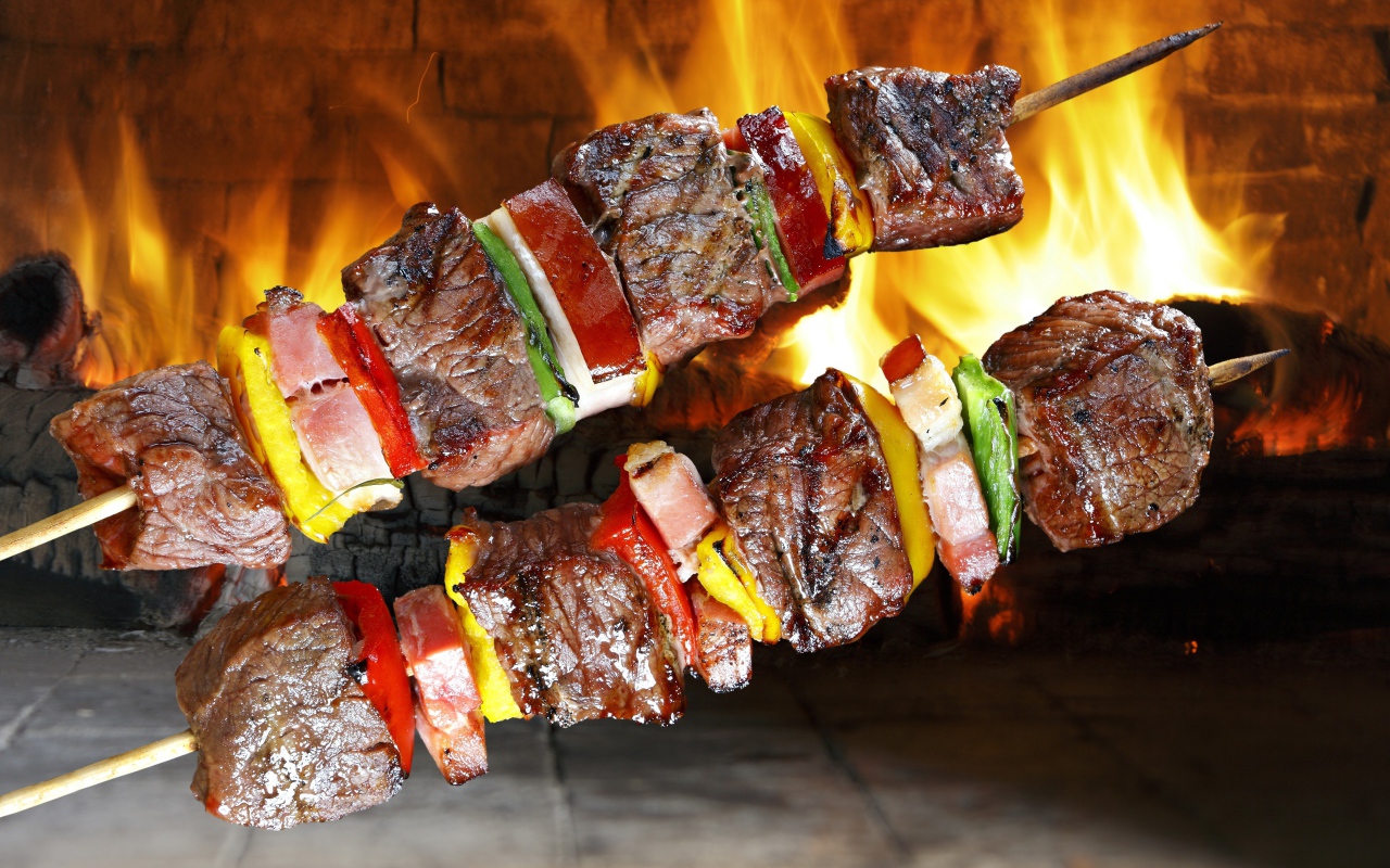 Аппетитный шашлык с овощами на фоне огня