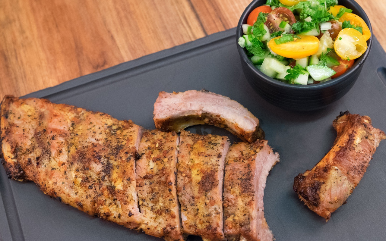 Жареные ребрышки с салатом на столе