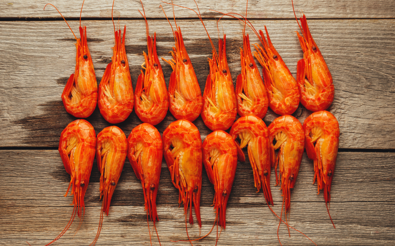 Красные вареные креветки на деревянном столе