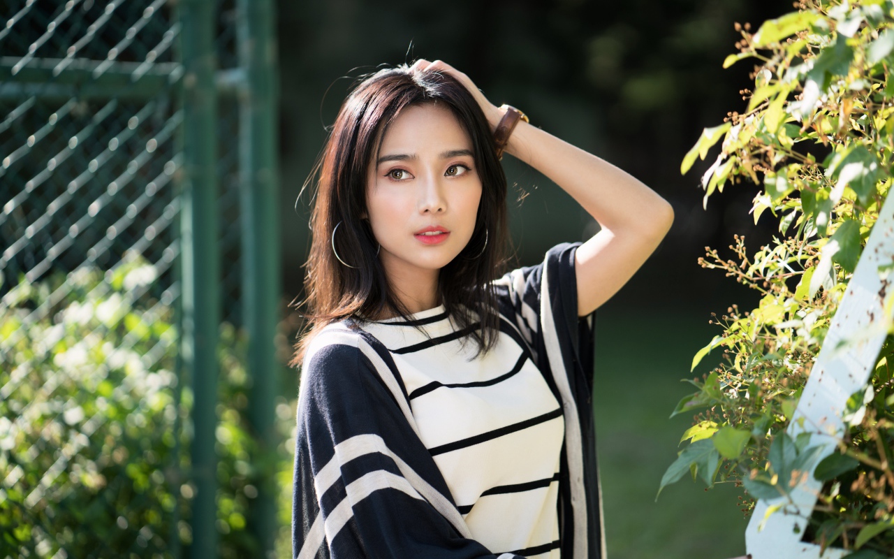 Красивая девушка азиатка с часами на руке 