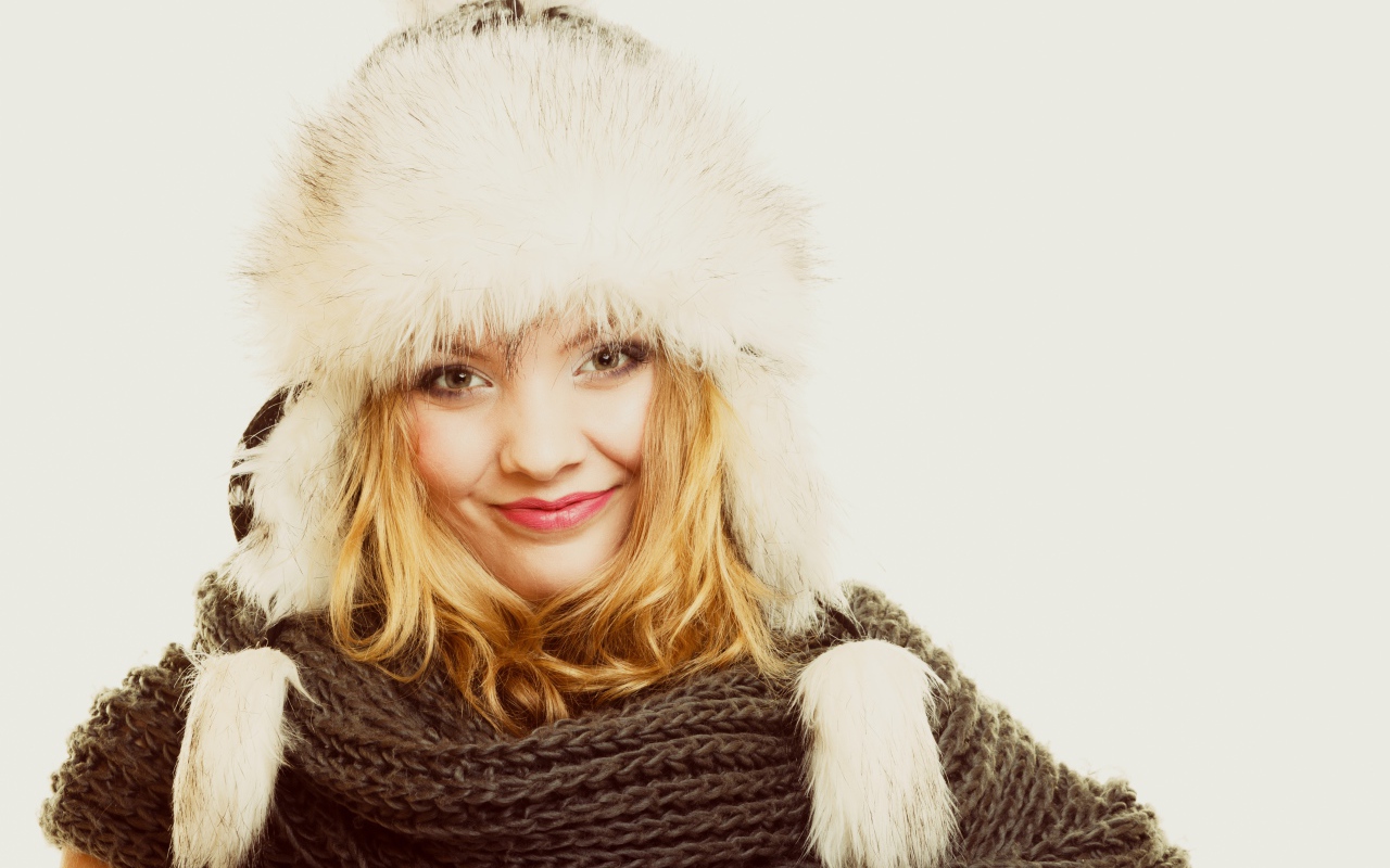 Красивая блондинка в теплой шапке с шарфом на шее