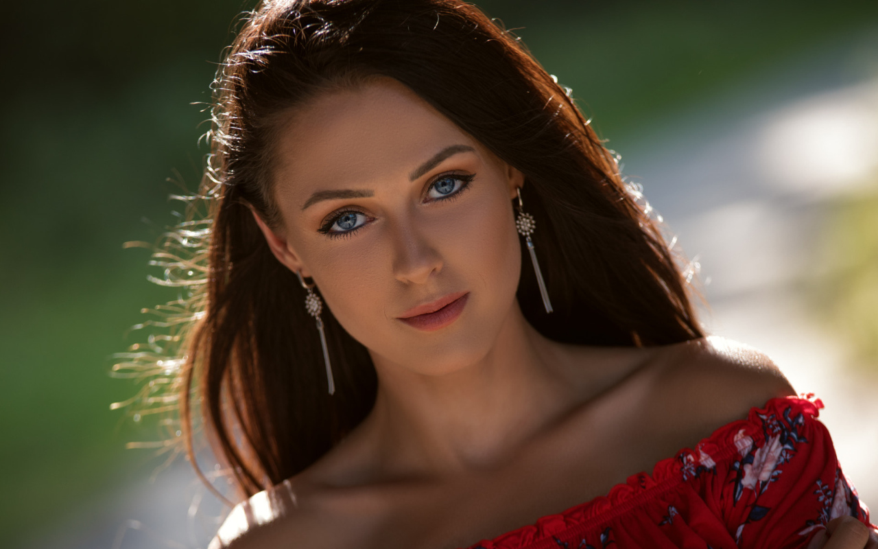 Красивая голубоглазая брюнетка с серьгами у ушах