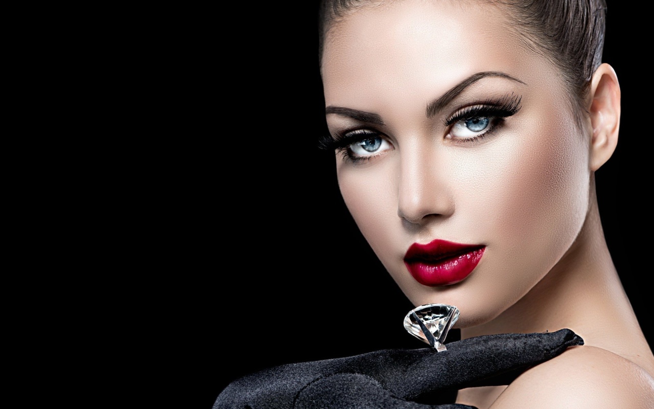 Beautiful blue-eyed girl with a ring on her finger on a black background