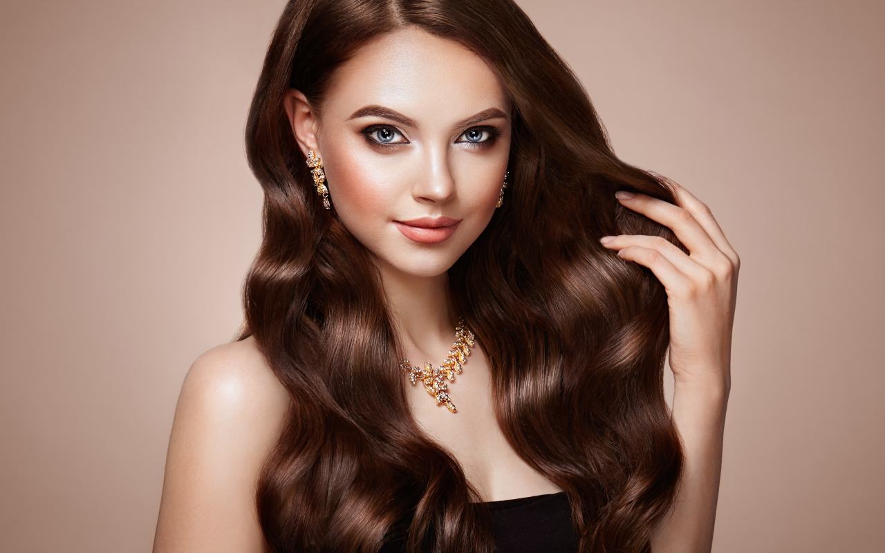 Красивая голубоглазая длинноволосая девушка шатенка с золотым украшением на шее 