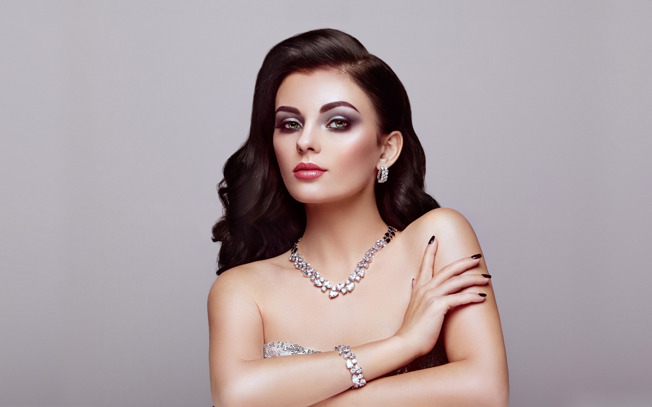 Красивая яркая брюнетка на сером фоне