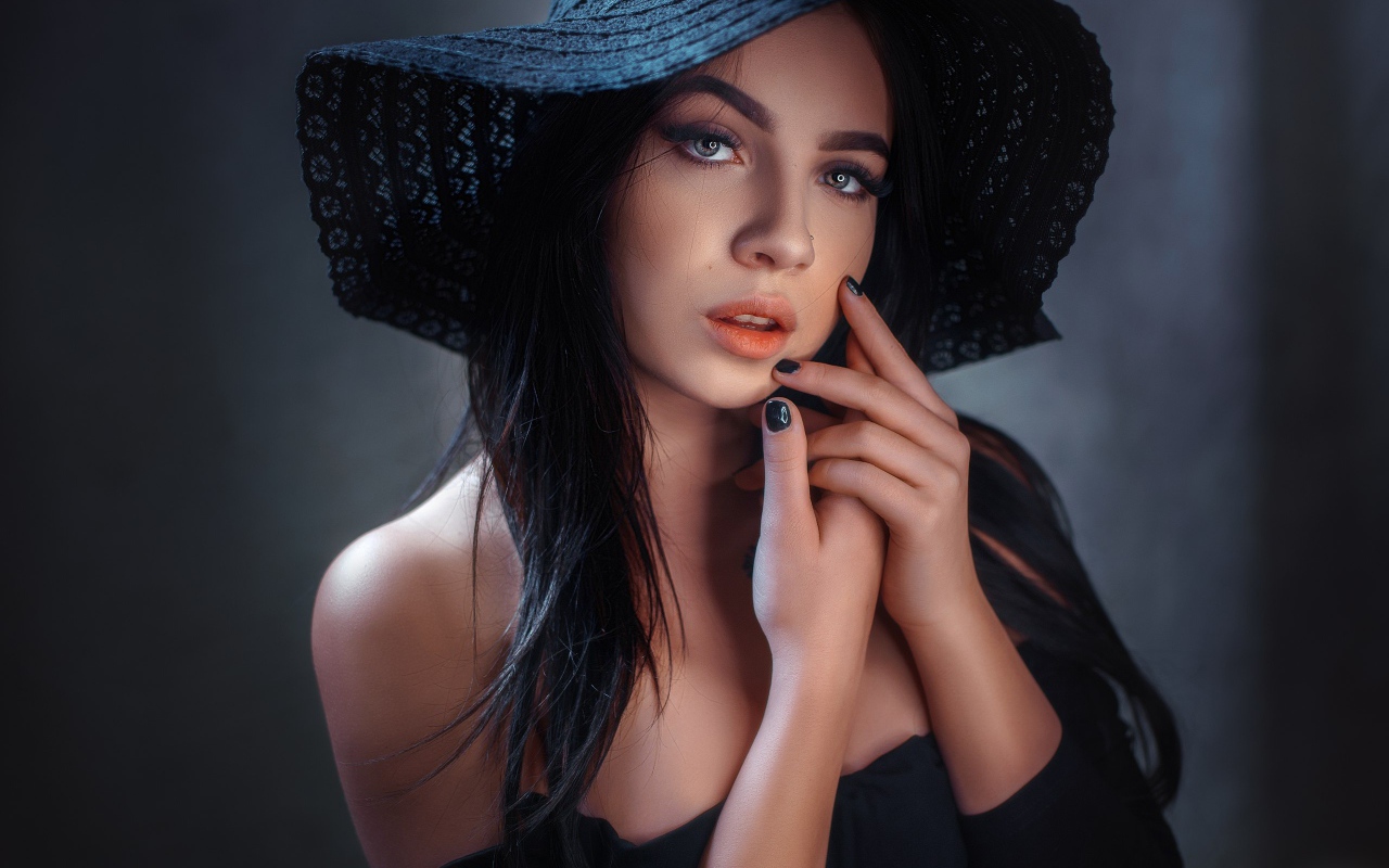 Красивая брюнетка в большой черной шляпе 