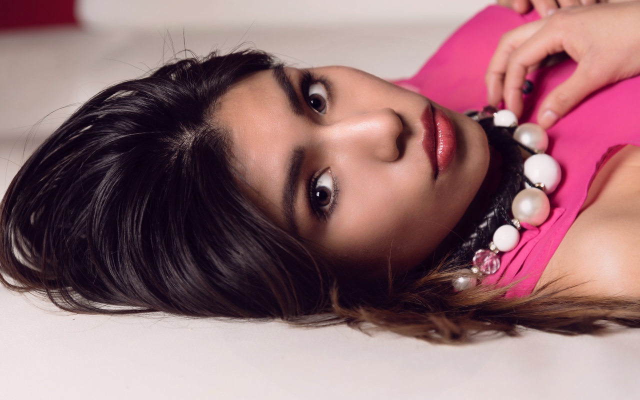 Красивая брюнетка с большими бусами на шее