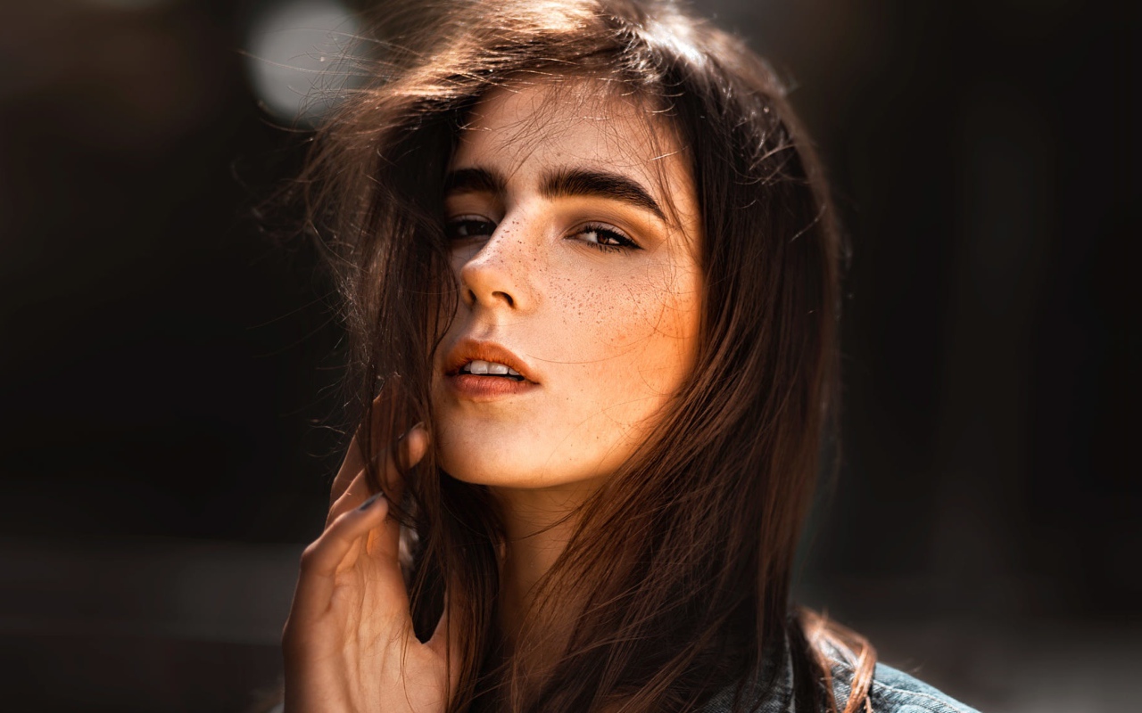 Красивая брюнетка с веснушками на лице
