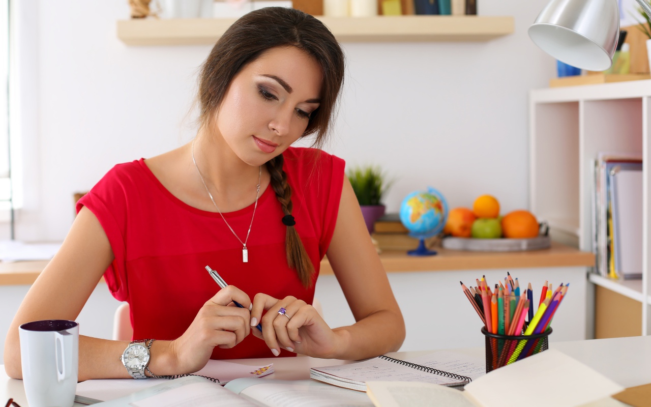 Красивая деловая девушка за столом с тетрадями