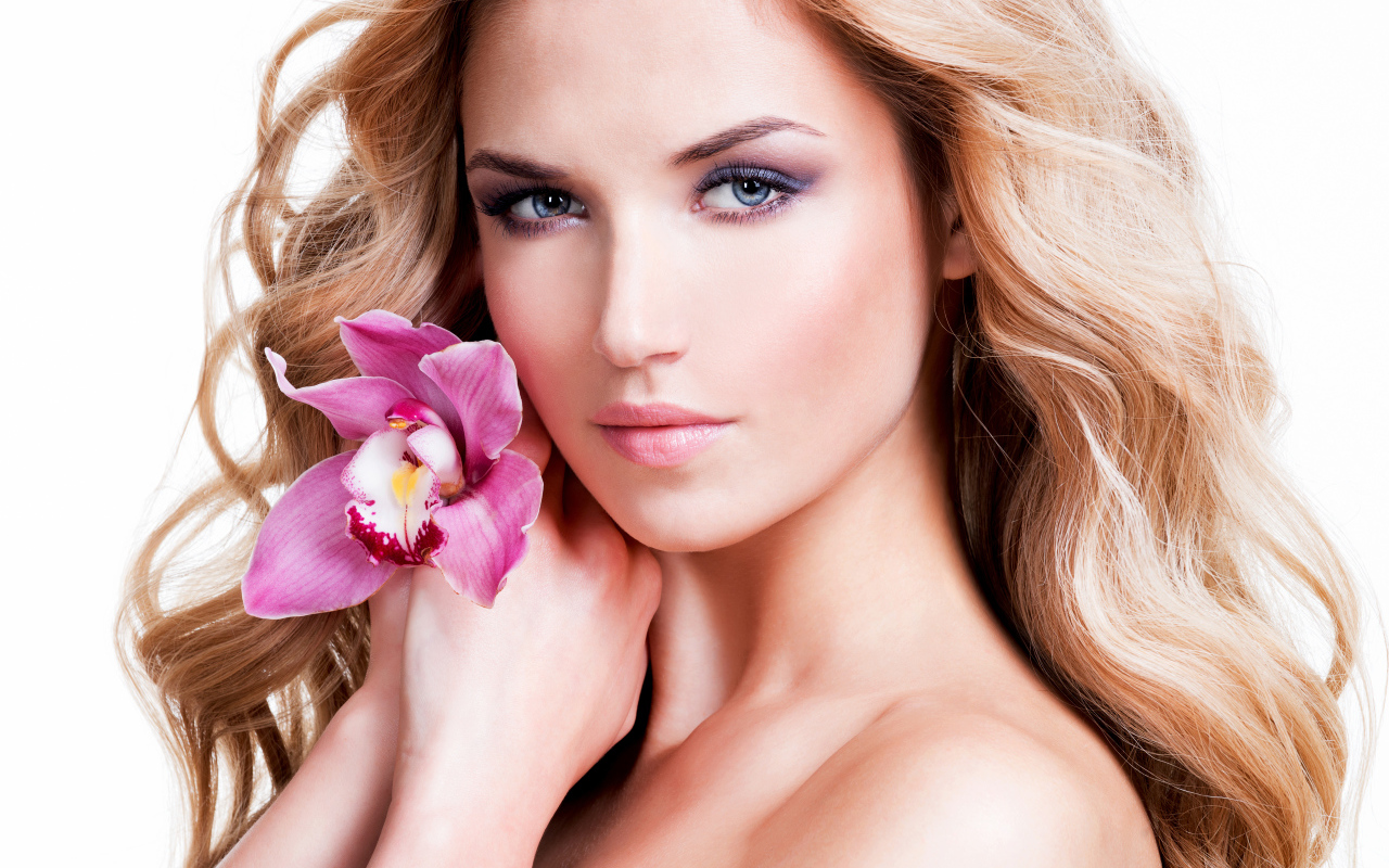 Красивая нежная блондинка с цветком орхидеи на белом фоне