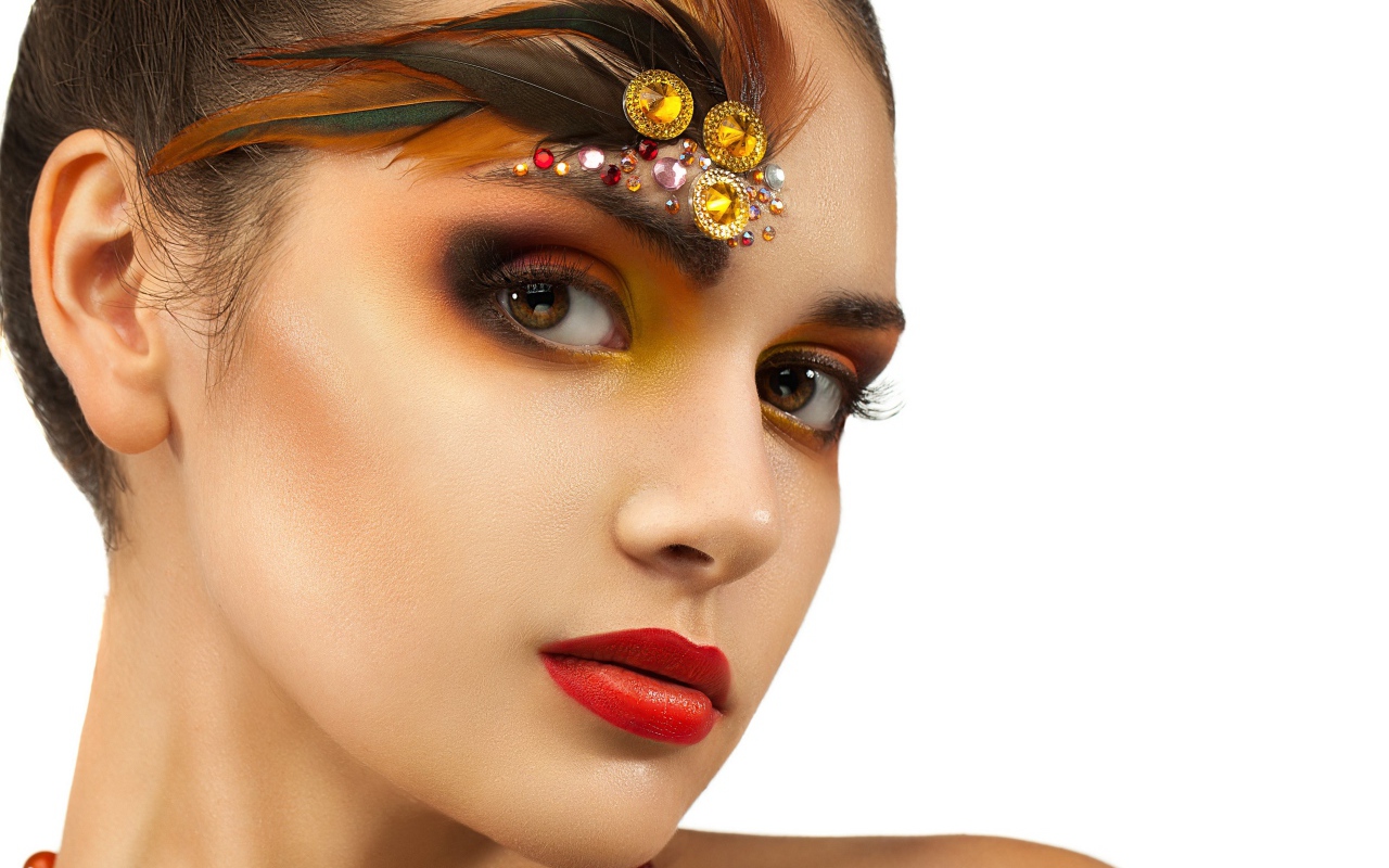 Красивая девушка с ярким макияжем и стразами на лице
