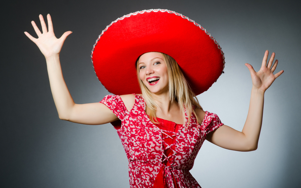 Красивая улыбающаяся блондинка в большой красной шляпе