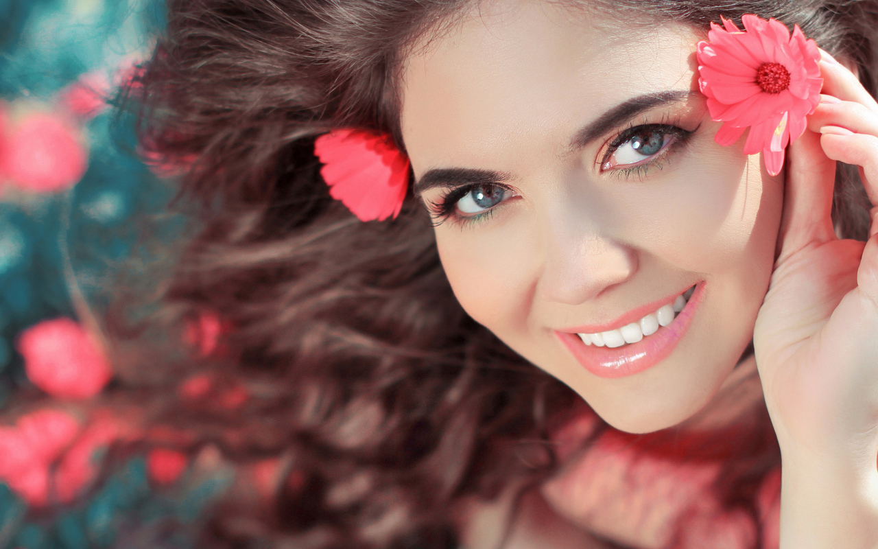 Красивая улыбающаяся девушка с цветами в волосах 