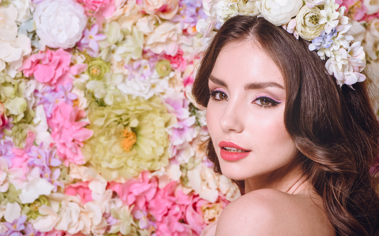 Красивая нежная девушка шатенка с венком на голове на фоне цветов