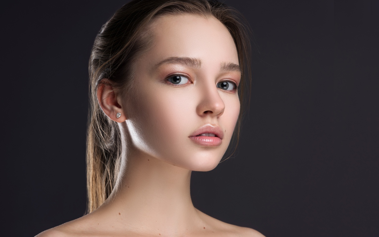 Нежная настоящая девушка шатенка на сером фоне