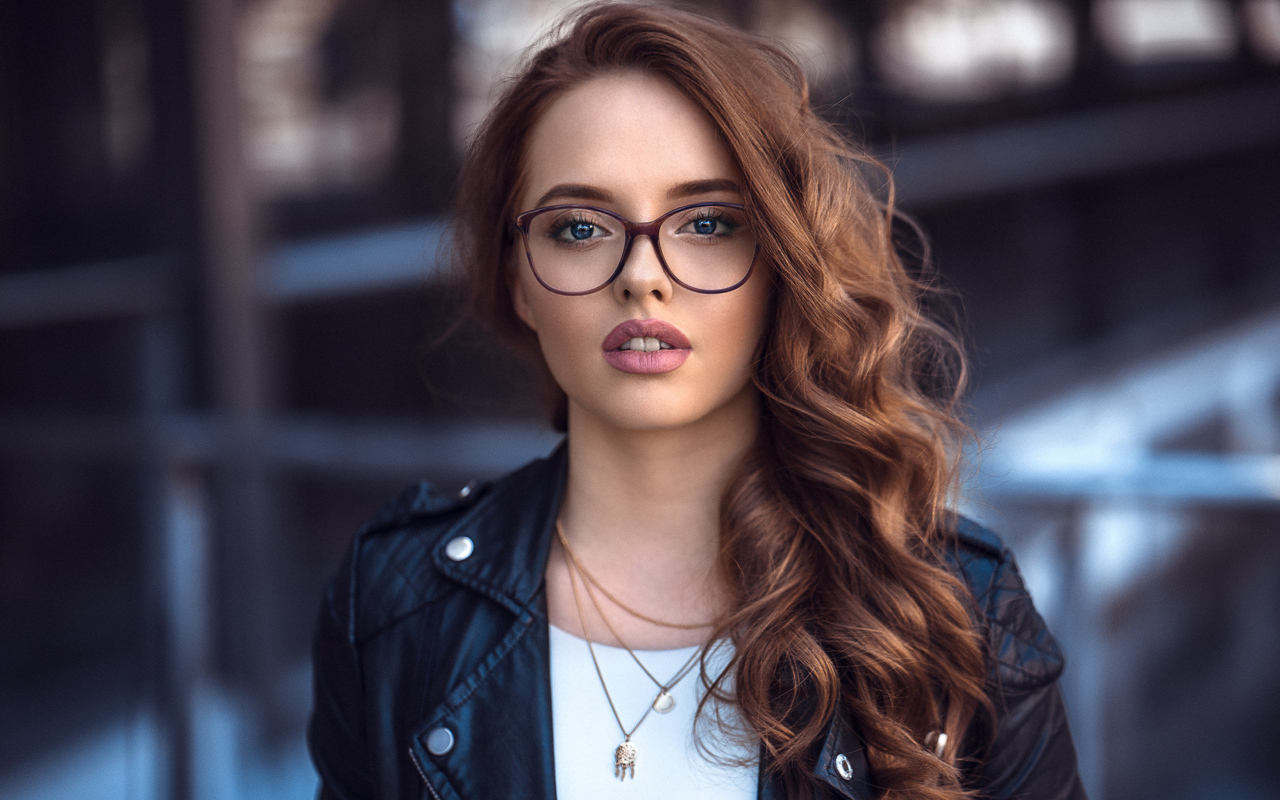 Девушка в черной куртке в очках 