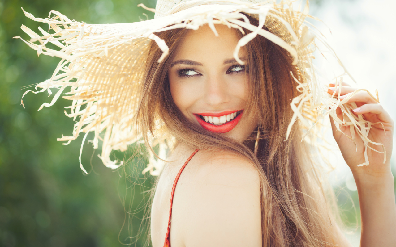 Улыбающаяся девушка в соломенной шляпе летом