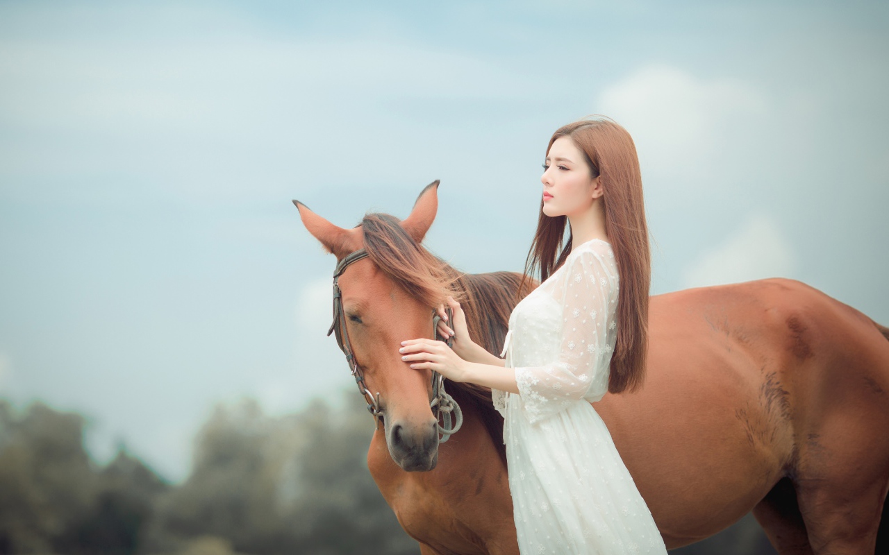 Молодая азиатка в белом платье с лошадью 