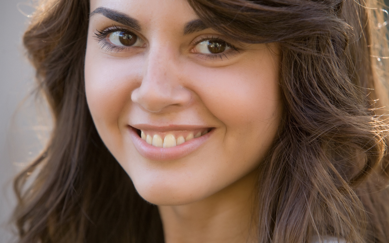 Молодая кареглазая брюнетка с очаровательной улыбкой