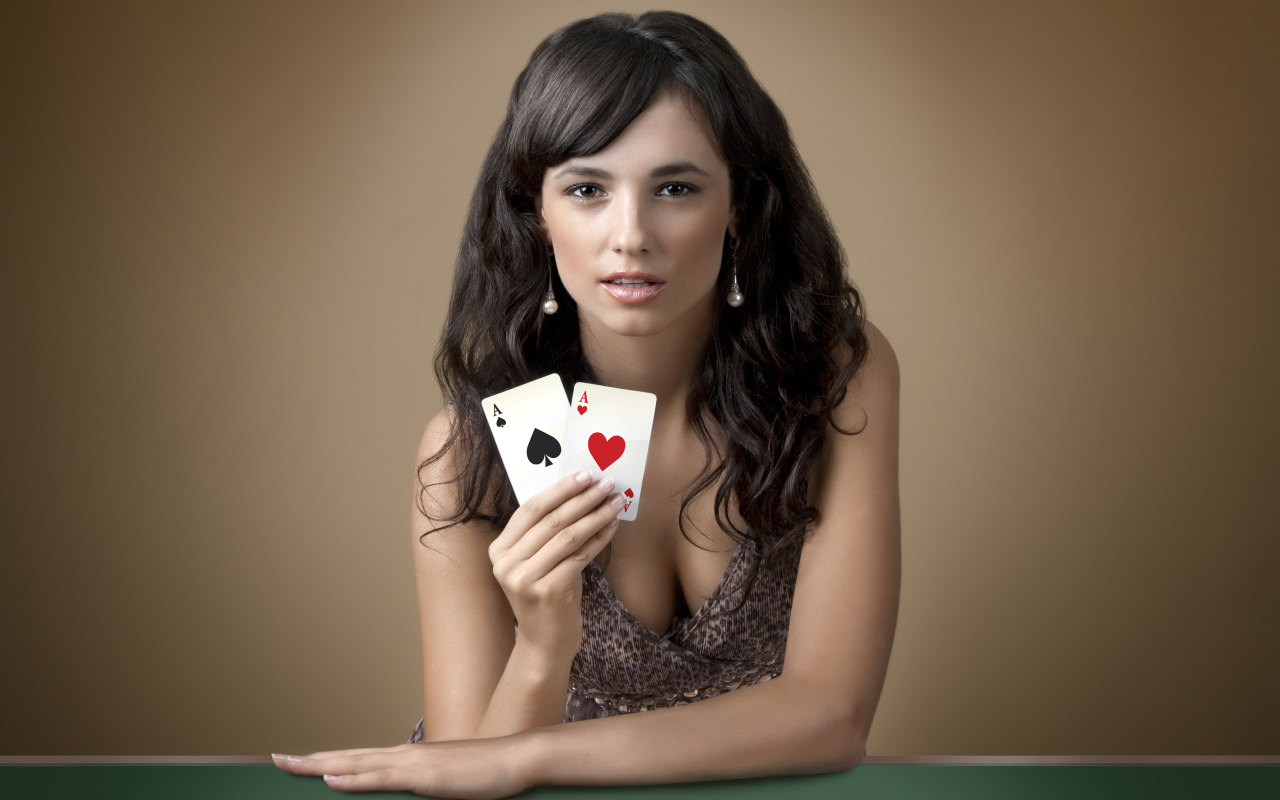 Молодая брюнетка с двумя карточными тузами в руке