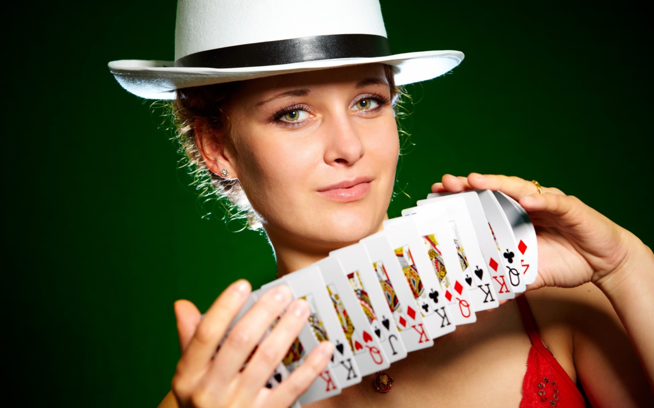 Молодая девушка в шляпе с картами в руках