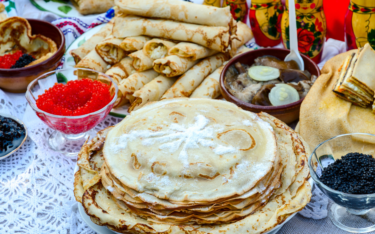 Вкусные праздничные угощения с блинами и икрой на столе к празднику Масленица