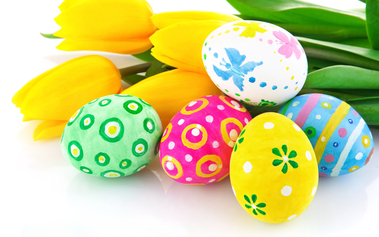 Разукрашенные яйца с букетом желтых тюльпанов на белом фоне на Пасху