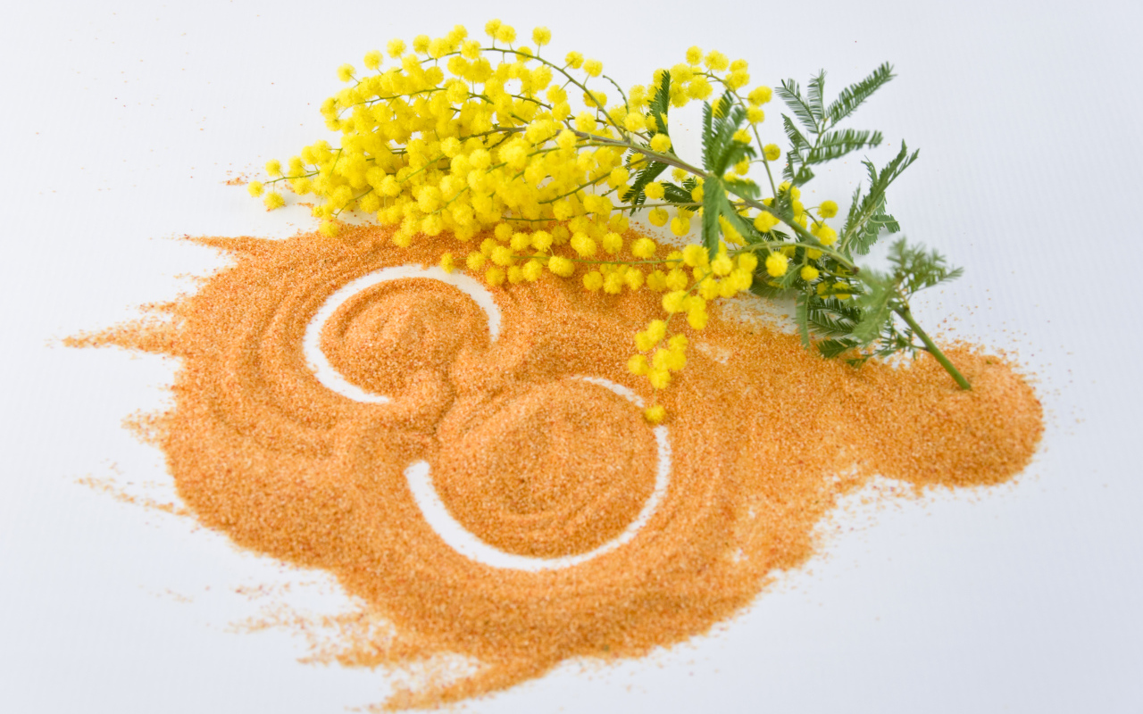 Цифра 8 на песке с веткой мимозы на Международный женский день 8 марта