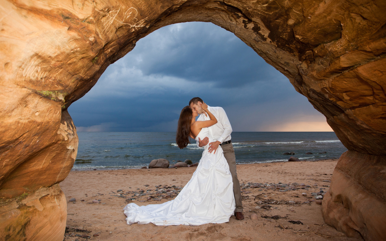 Поцелуй жениха и невесты на фоне моря