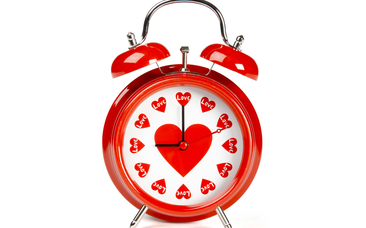 Красный будильник с сердечками на белом фоне
